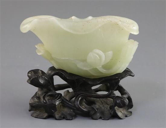 A Chinese pale celadon jade lotus brushwasher, 18th/19th century, L. 9.7cm, carved wood lotus stand
